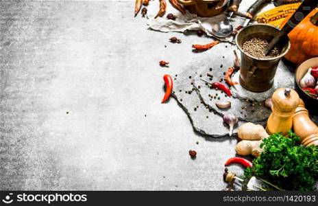 Fresh spices, herbs and autumn vegetables. On a stone background.. Fresh spices, herbs and autumn vegetables