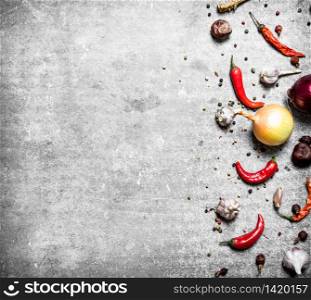 Fresh spices, onion and garlic. On a stone background.. Fresh spices