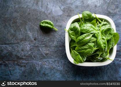 Fresh spinach leaves in a bowl, green vegetables, rustic style, healthy lifestyle, proper nutrition. Top view, space for text