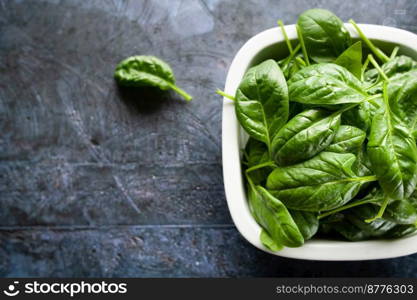 Fresh spinach leaves in a bowl, green vegetables, rustic style, healthy lifestyle, proper nutrition. Top view, space for text