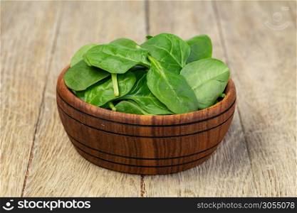 Fresh spinach leaves in bowl on wooden background. Fresh spinach leaves in bowl