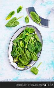 fresh spinach on metal plate on a table