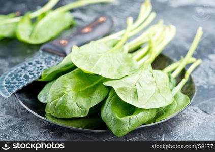 fresh spinach on plate and on a table