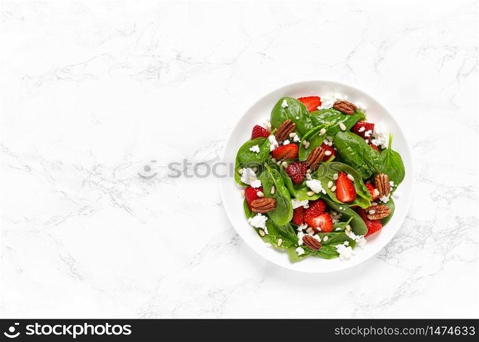 Fresh spinach salad with strawberry, pine and pecan nuts, goat cheese, maple syrup dressing