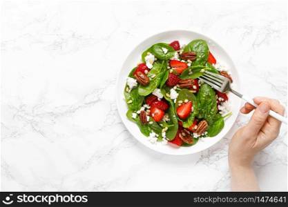 Fresh spinach salad with strawberry, pine and pecan nuts, goat cheese, maple syrup dressing