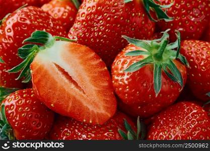 Fresh Strawberries. Half a strawberry and a whole berry close-up. Background of ripe strawberries, delicious natural dessert