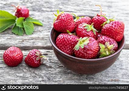 Fresh strawberries in a bowl on a wooden table. close-up. Fresh strawberries in a bowl on a wooden table.
