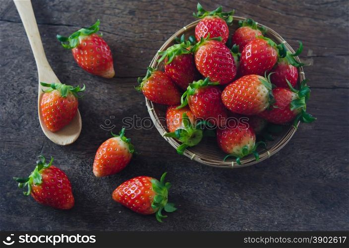 Fresh strawberries on basket , over old wooden background