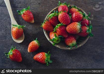 Fresh strawberries on basket , over old wooden background