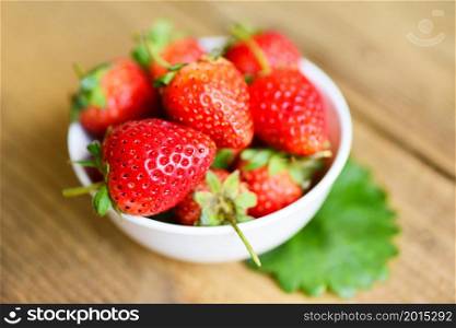 Fresh strawberries on white bowl on the table, Red ripe strawberry on wooden background
