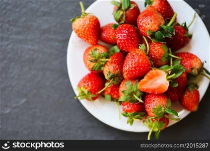 Fresh strawberries on white plate on the table, Red ripe strawberry on dark background