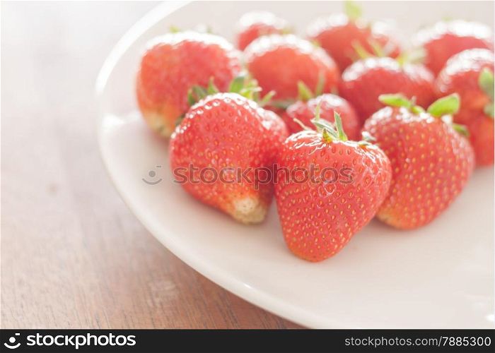 Fresh strawberries on white plate, stock photo