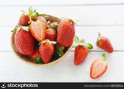 fresh strawberries on wooden background / ripe red strawberry picking in basket