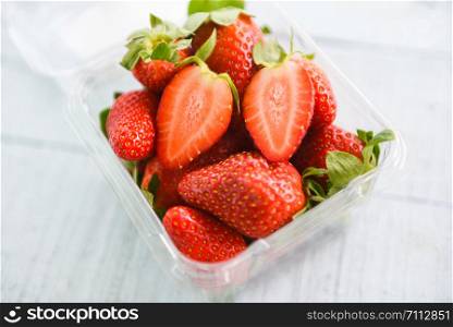 fresh strawberries on wooden background / ripe red strawberry picking in box