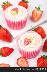 Fresh strawberry cupcake muffins with raw berries on marble board