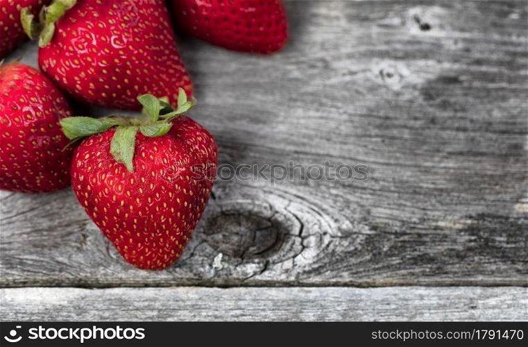 Fresh strawberry fruit on rustic wooden planks setting in close up view
