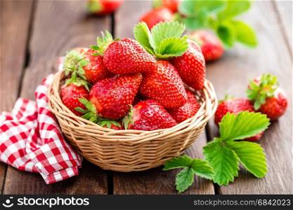 Fresh strawberry in basket on wooden rustic table, closeup. Delicious, juicy, red berries. Healthy eating.