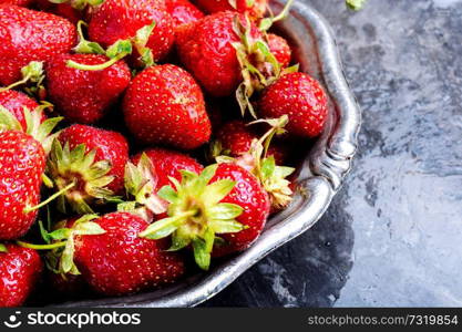 Fresh strawberry in bowl on concrete table. Fresh juicy strawberries