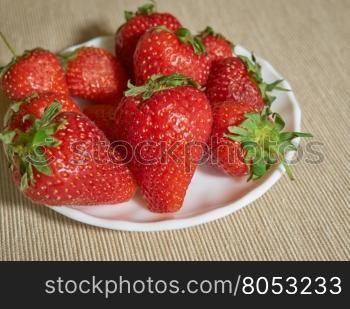 fresh strawberry lying on a plate closeup. fresh strawberry lying on a white plate closeup