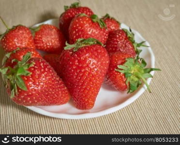 fresh strawberry lying on a plate closeup. fresh strawberry lying on a white plate closeup