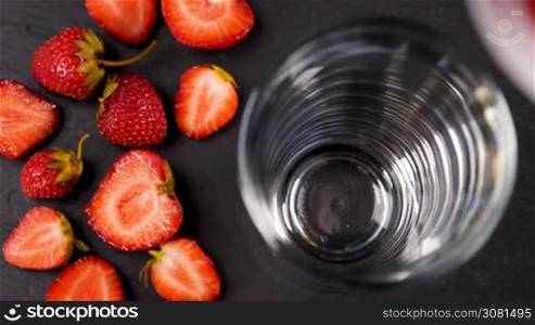 Fresh strawberry smoothie flowing in glass in slow motion. Healthy drinking concept.