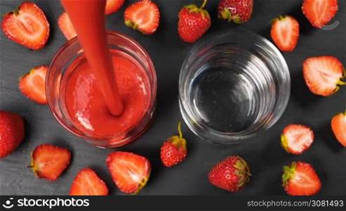 Fresh strawberry smoothie flowing in glasses ready to drink. Healthy drinking concept.