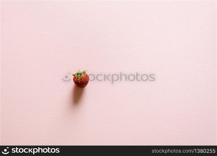 Fresh strawberry top view on a pink background. Organic fruits. Single strawberry minimalistic on a pastel pink table. Summer fruits