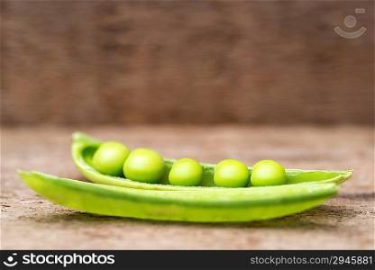 Fresh sugar snap peas in pod on rustic wooden background