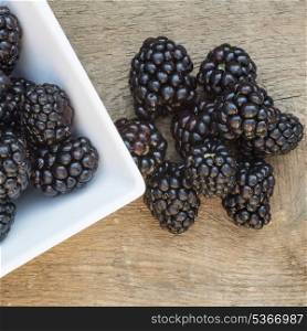 Fresh Summer blackberries on rustic wooden background. Macro image of fresh Summer blackberries