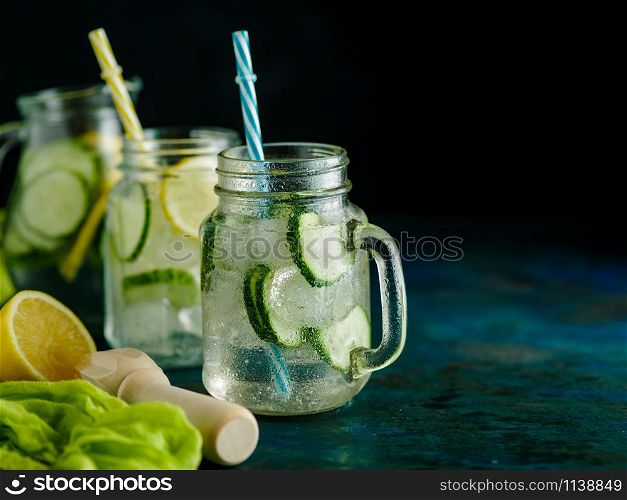 Fresh Summer Drink. Healthy detox fizzy water with lemon and cucumber in mason jar over dark background. Healthy food concept. Detox diet.