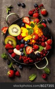 fresh summer fruits and berries on plate, above, rustic background