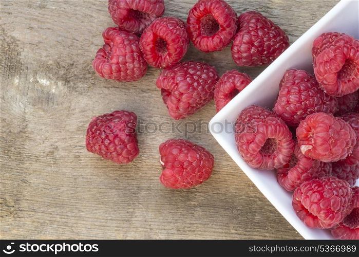 Fresh Summer raspberries on rustic wooden background. Macro image of fresh Summer raspberries