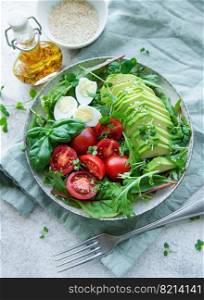 Fresh summer salad with arugula,  red cherry tomatoes, basil, eggs and avocado. Vegan food. Healthy salad