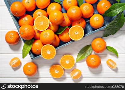 Fresh tangerine fruits with leaves on wooden table. Healthy food concept. Vitamin C