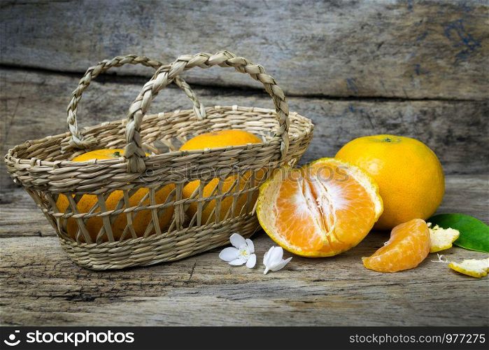 Fresh tangerines in a basket on grunge wooden background