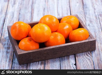 fresh tangerines in wooden box and on a table