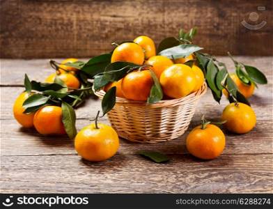 fresh tangerines with leafs on wooden background