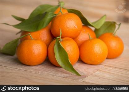 fresh tangerines with leaves on a wooden table