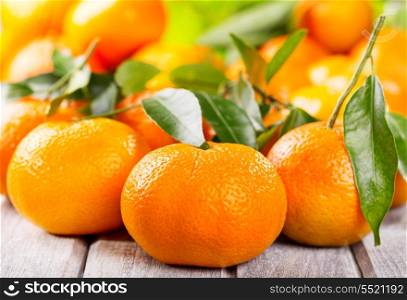 fresh tangerines with leaves on wooden table