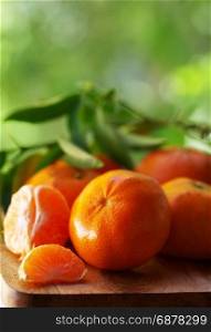fresh tangerines with leaves on wooden table