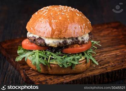 fresh tasty burger on wood table. Burger on a wooden board. Burger on a wooden board