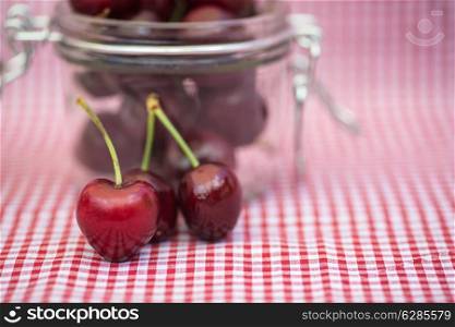 Fresh tasty cherries in glass storage jar