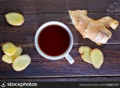 fresh tea in cup and ginger on a table