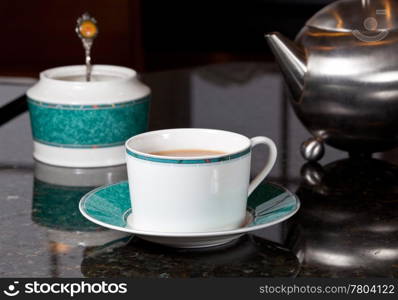 Fresh tea poured into white cup on marble kitchen worktop