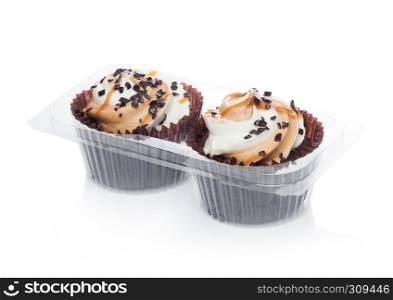 Fresh toffee cupcakes muffin with caramel and chocolate in plastic tray on white background