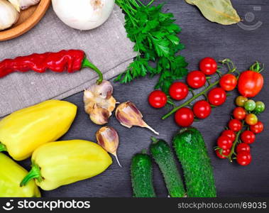 Fresh tomato, cucumber and pepper on a black background, top view