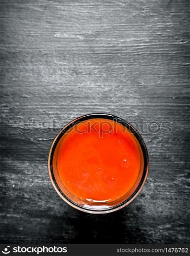 Fresh tomato juice in the glass.On black rustic background.. Fresh tomato juice in the glass.