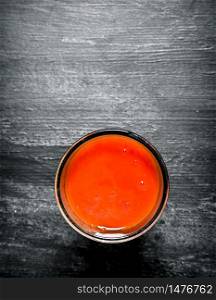 Fresh tomato juice in the glass.On black rustic background.. Fresh tomato juice in the glass.