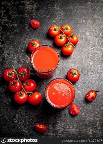 Fresh tomato juice. On a black background. High quality photo. Fresh tomato juice. On a black background.