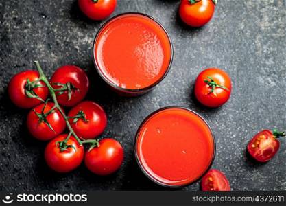 Fresh tomato juice. On a black background. High quality photo. Fresh tomato juice. On a black background.